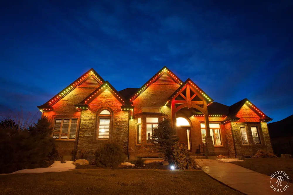 Home with amber holiday lighting on every gable