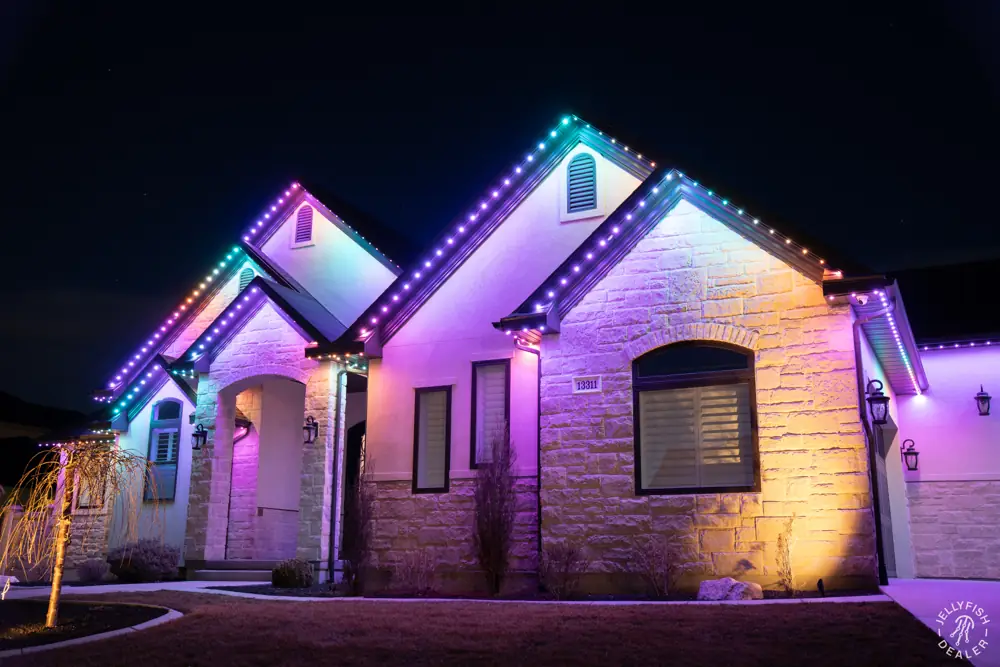 Home with purple roofline and warm landscape lighting